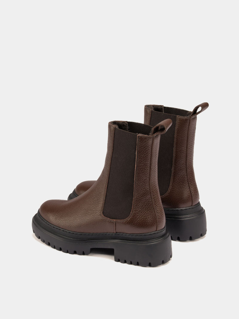 Pair of brown Chelsea boots on a light gray background