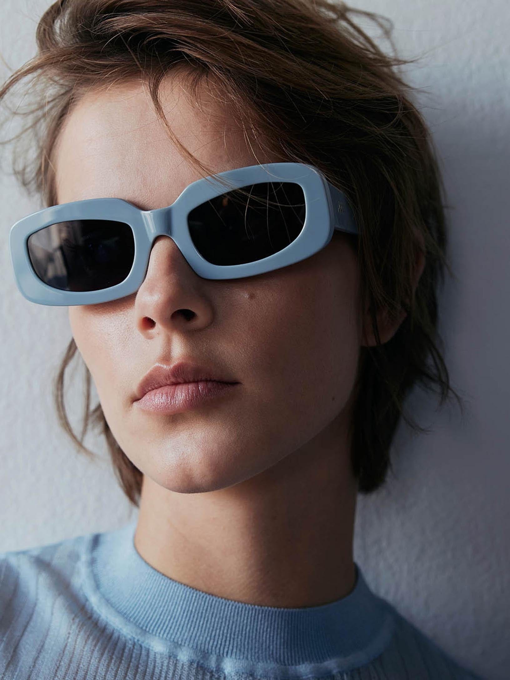 Model with short hair and blue sunglasses