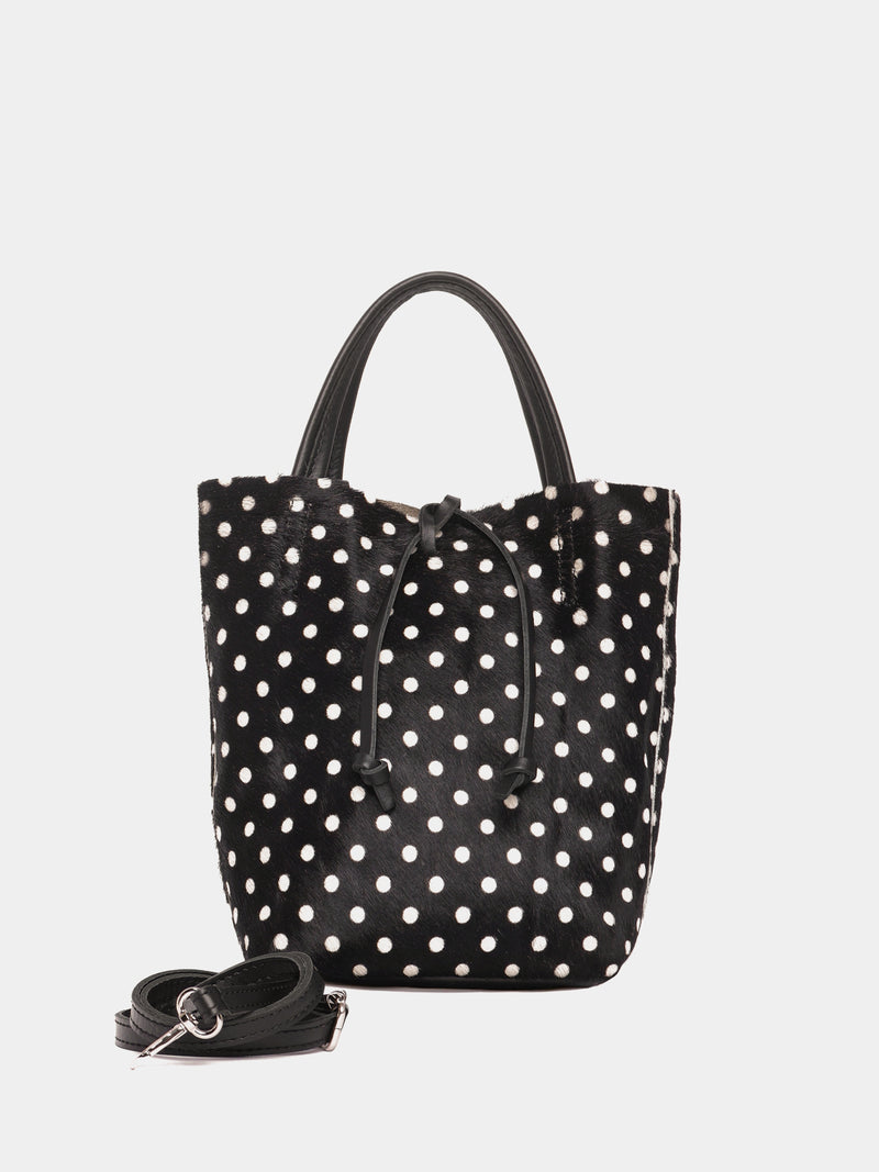 Black tote bag with white polka dots with a black crossbody strap