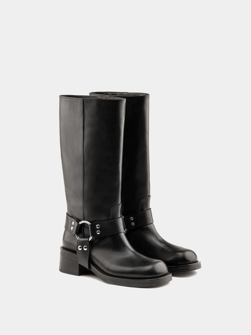 Knee-high black moto boots with a silver harness