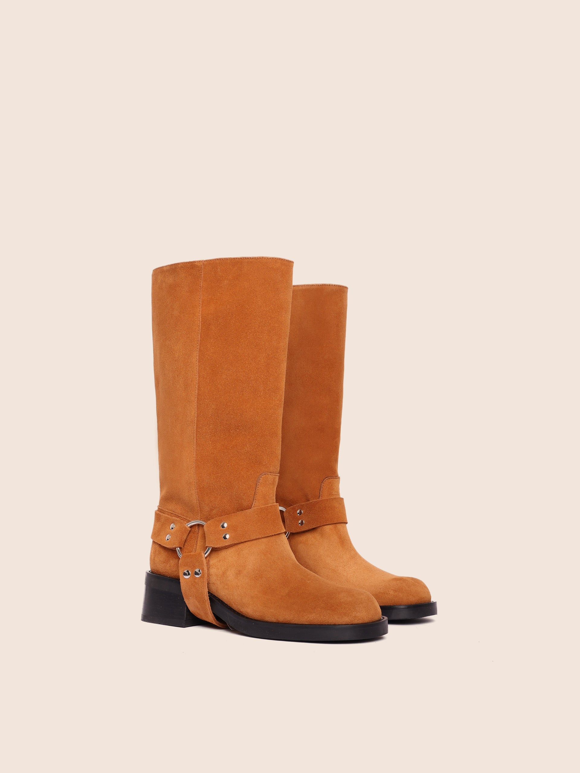 A tan suede boot with harness detailing and a mid-height heel, made in Italy.