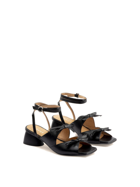 Mira black leather square-toe heel with ankle strap, showing two bows on front.