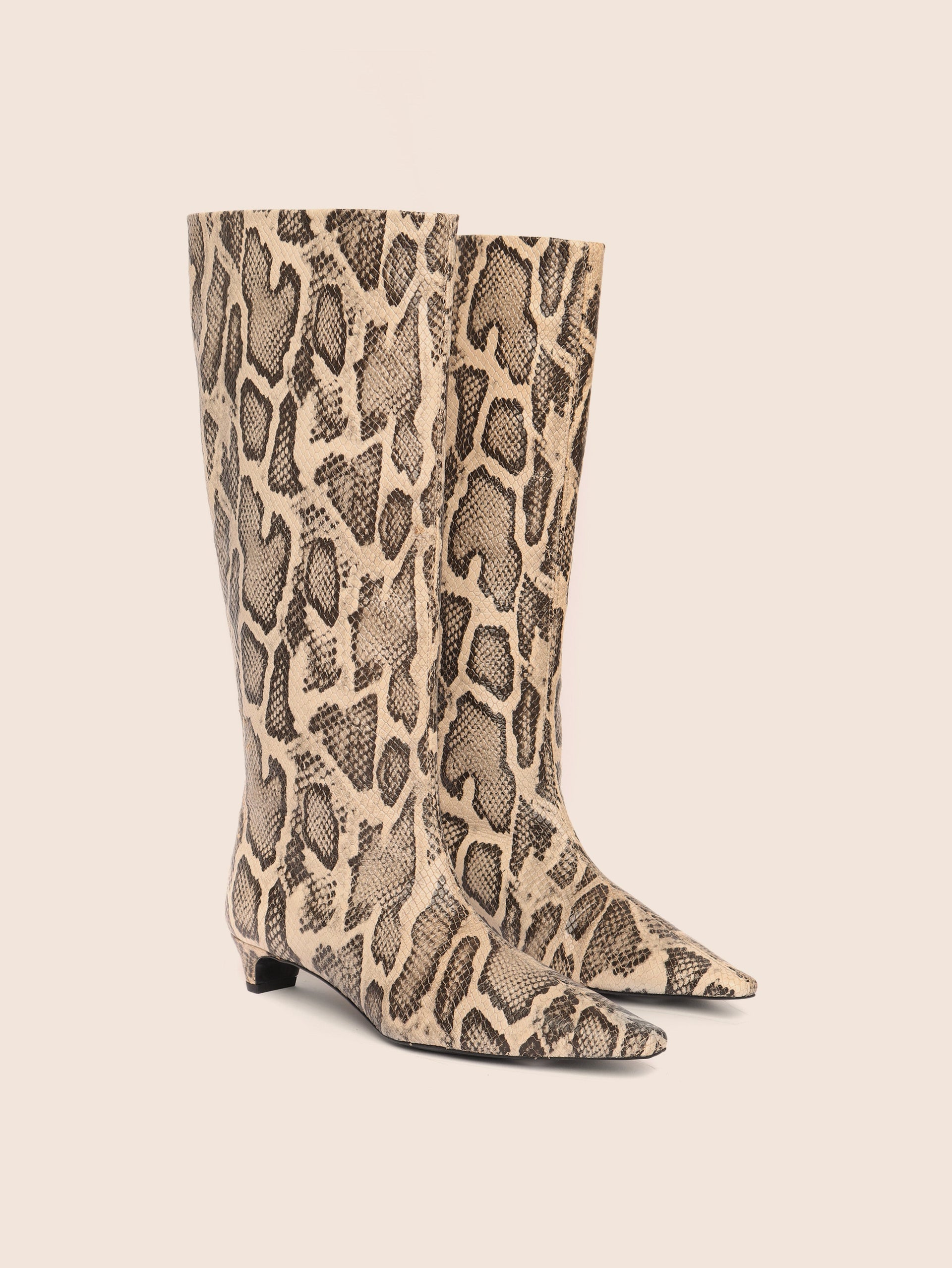 Snake print knee-high boots on a beige background