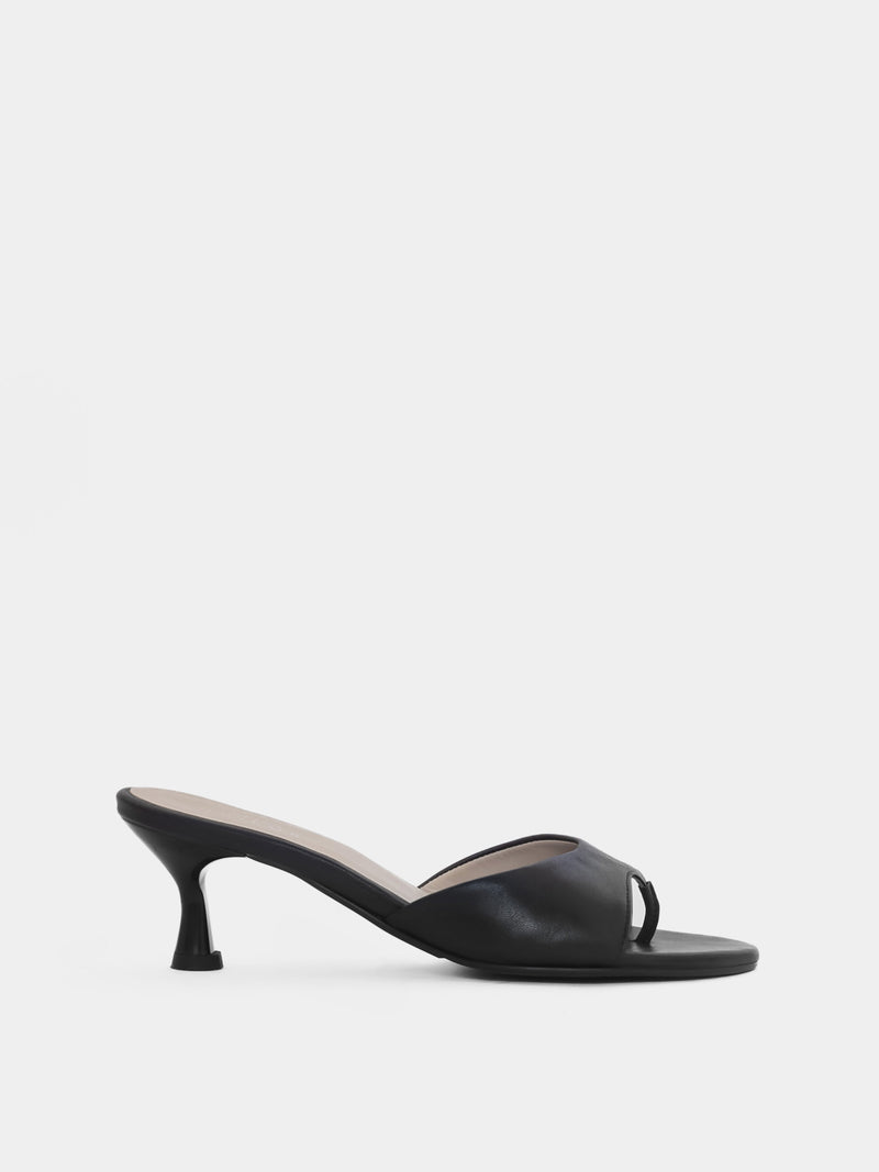 Side view of black open toe heeled sandal on white background