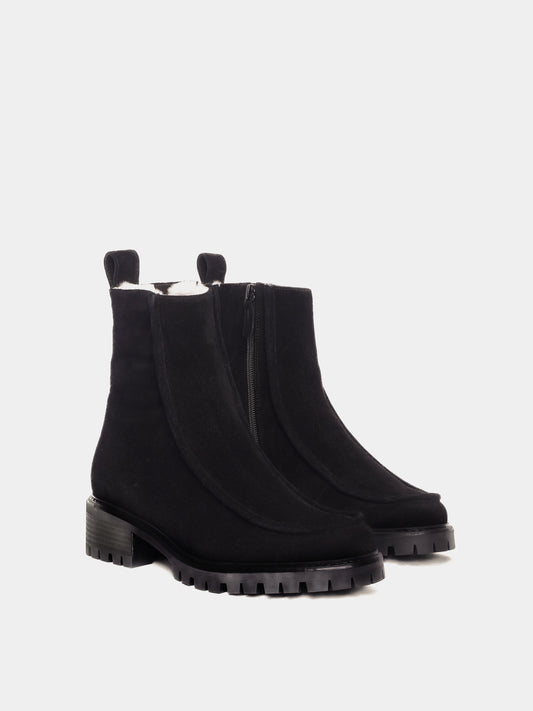 Shearling lined winter boot with a front piping detail, in a black suede with a black lug outsole. 
