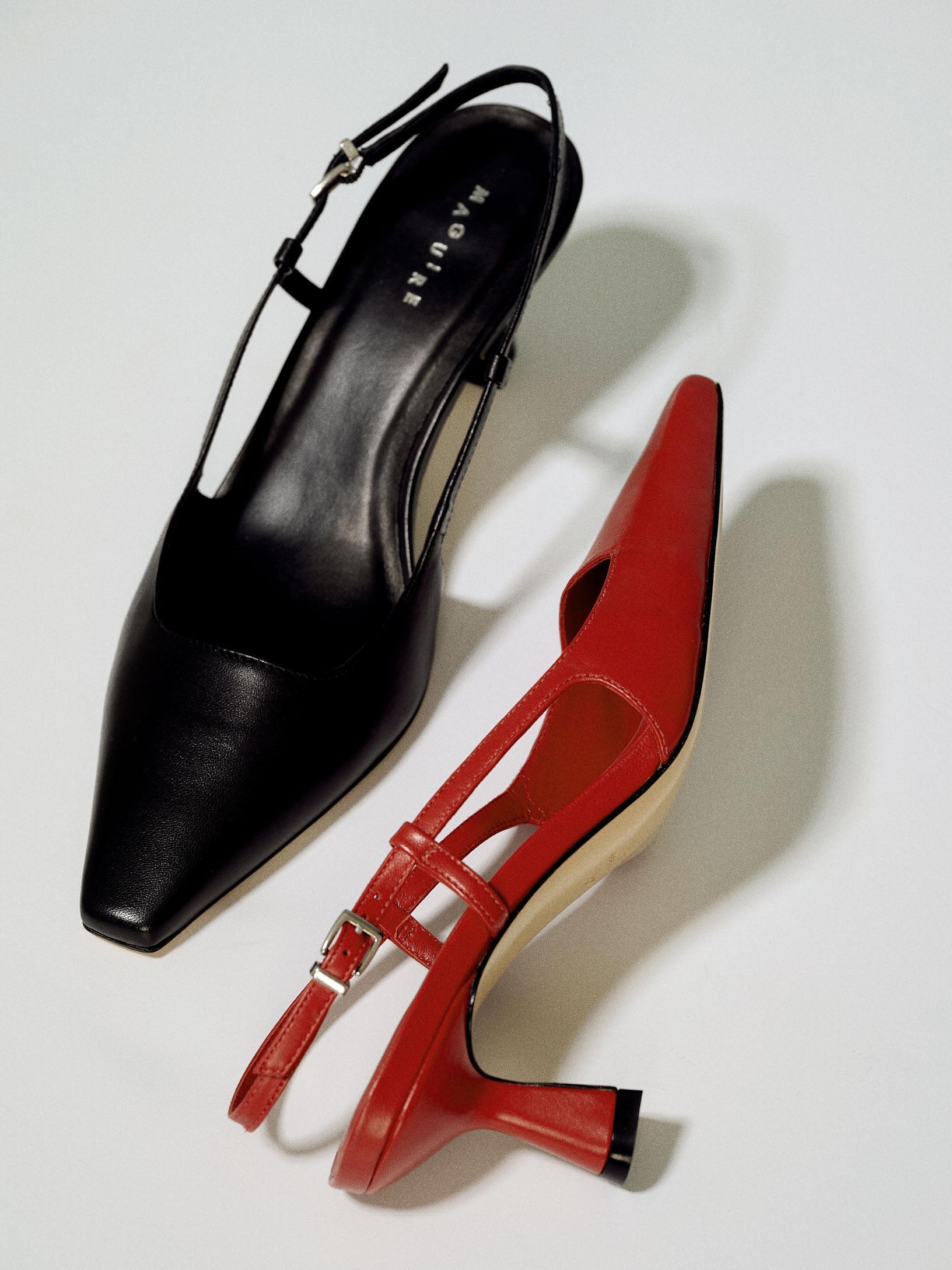 A black pointy pump and a red pointy pump on a white background