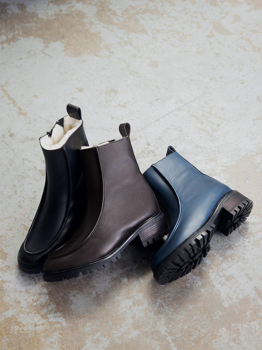 Shearling lined winter boots with a front piping detail. Front left to right: Black leather, Dark brown leather, Navy leather. 