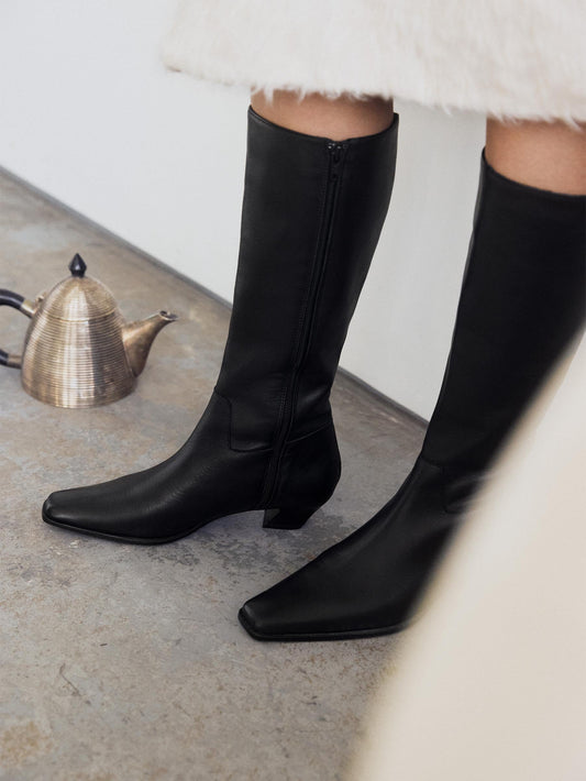 Close up on black boot with pointy toes