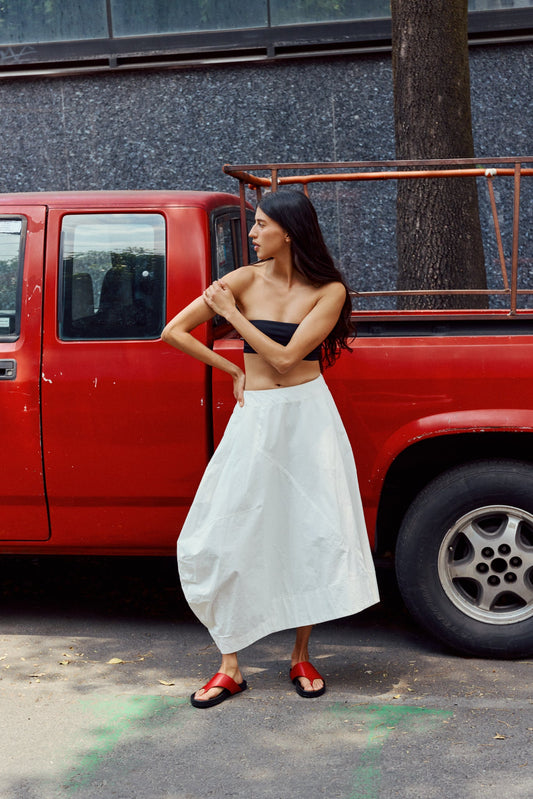Woman wearing red sandals in front of red truck.