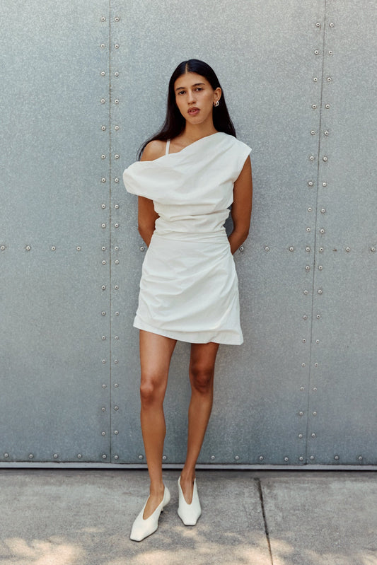 Woman in white dress and white heels on a street corner