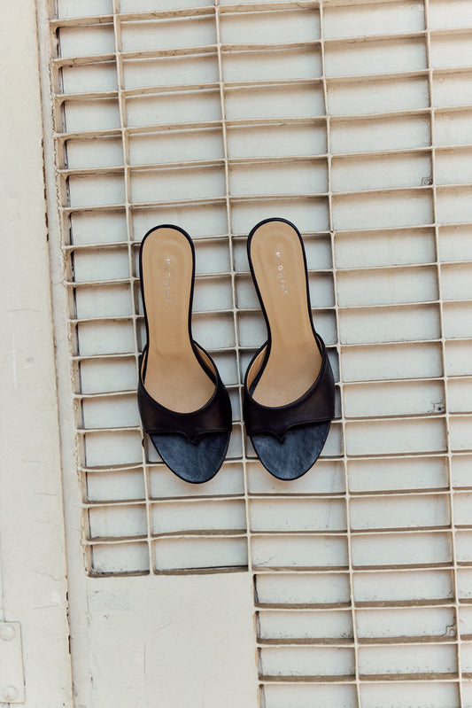 Black open toe heeled sandal on ground