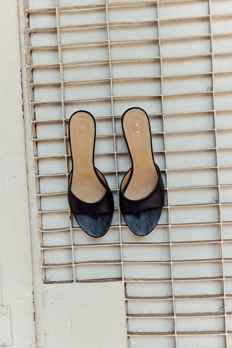 Black open toe heeled sandal on ground