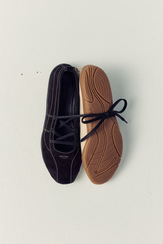 black ballet flat next to ream ballet flat, face down