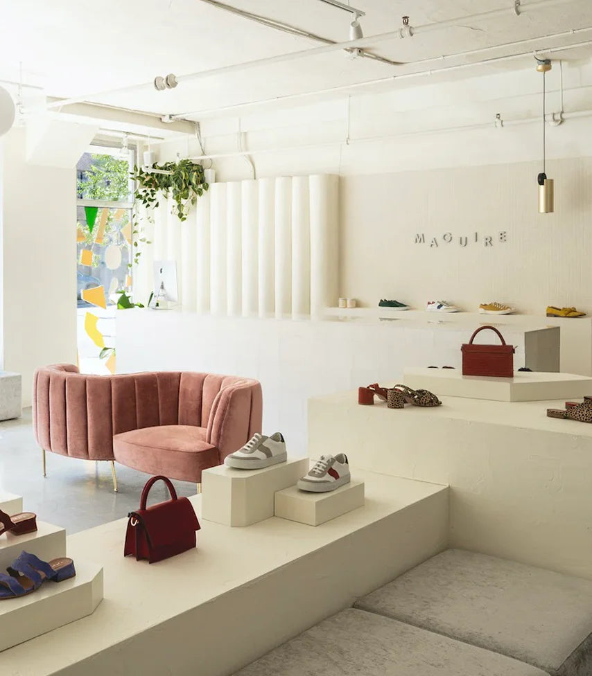 A corner of our Montreal store, featuring our signature pink sofas against warm cream walls, with our shoes beautifully displayed throughout the space.