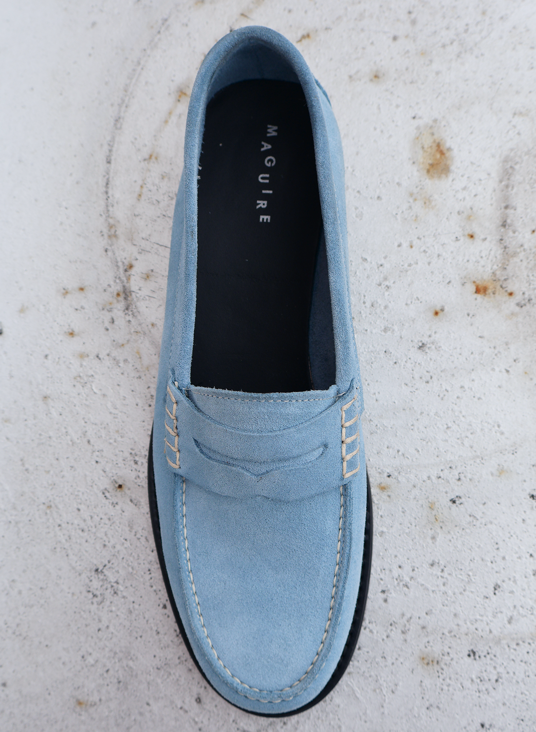 Light blue loafer shoe on a textured surface
