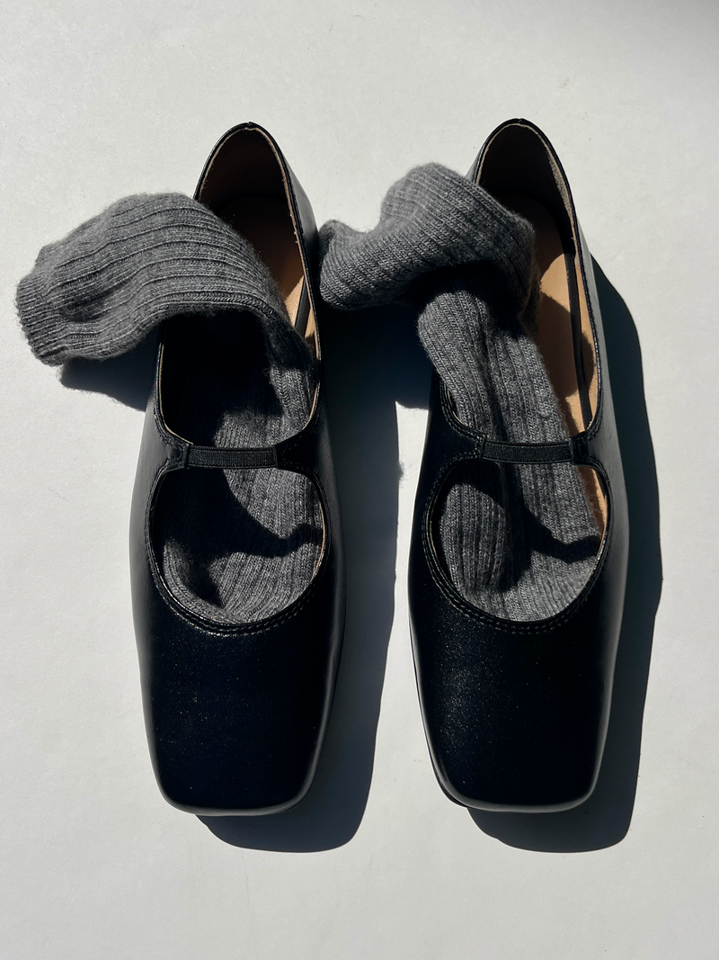 Seia Black shoes with gray socks on a light gray background