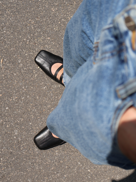 Square toe ballet flat with two elastic straps on the vamp and stitching detailing all over, in a soft black leather. 